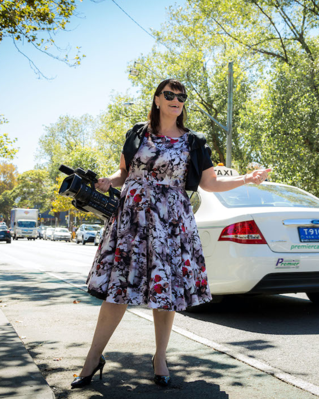 Monica Davidson, Founder of Creative+Business smiling on leafy street holding camera