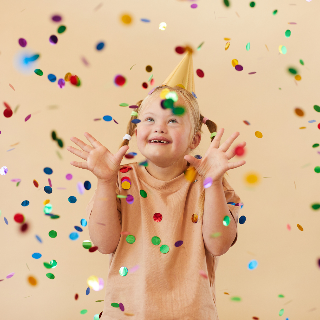 Child celebrating with confetti and party hat